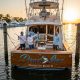 Fishing charter boat at sunset, showcasing custom boat graphics and apparel branding.